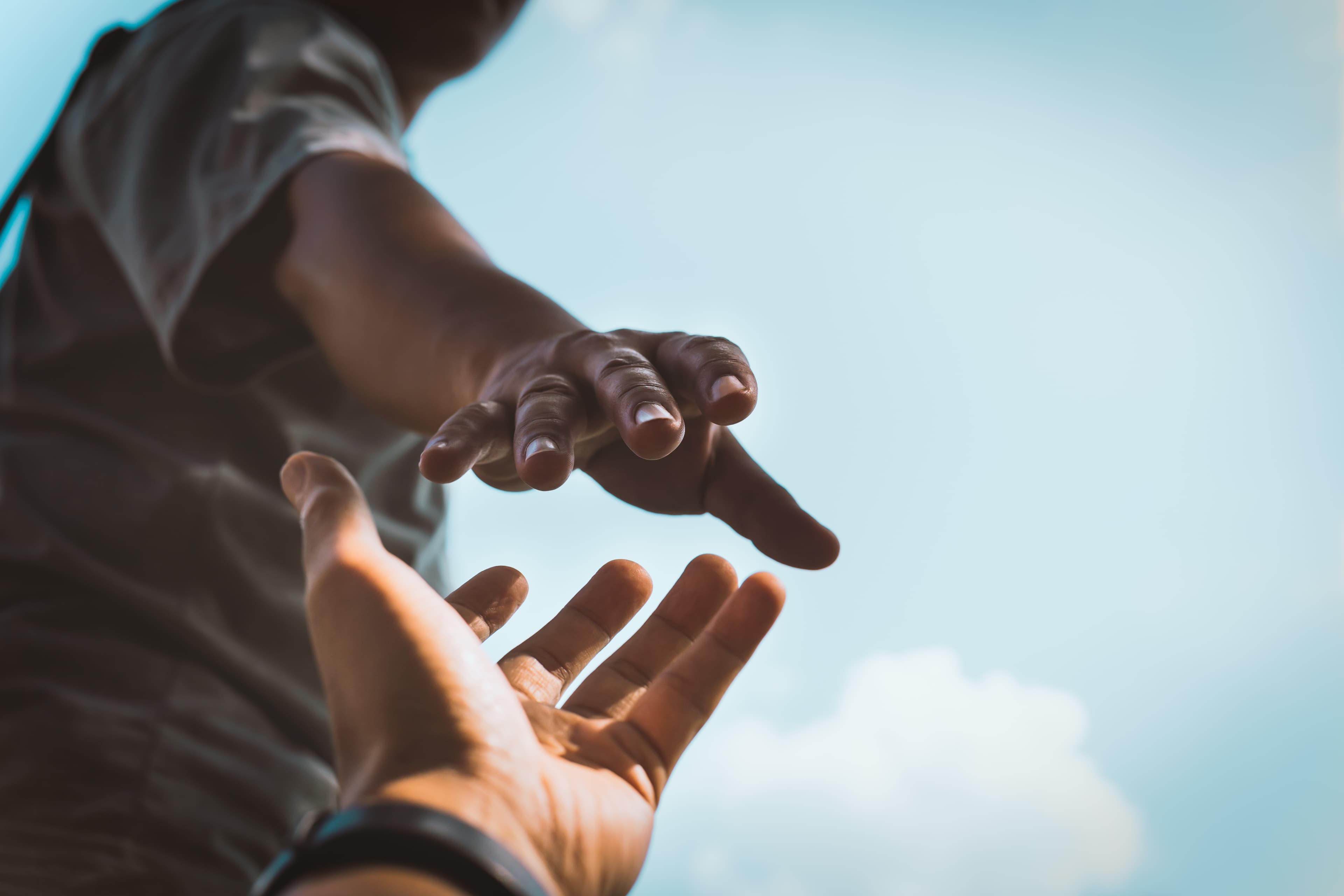 An outstretched hand offering a hand up — help reaching another